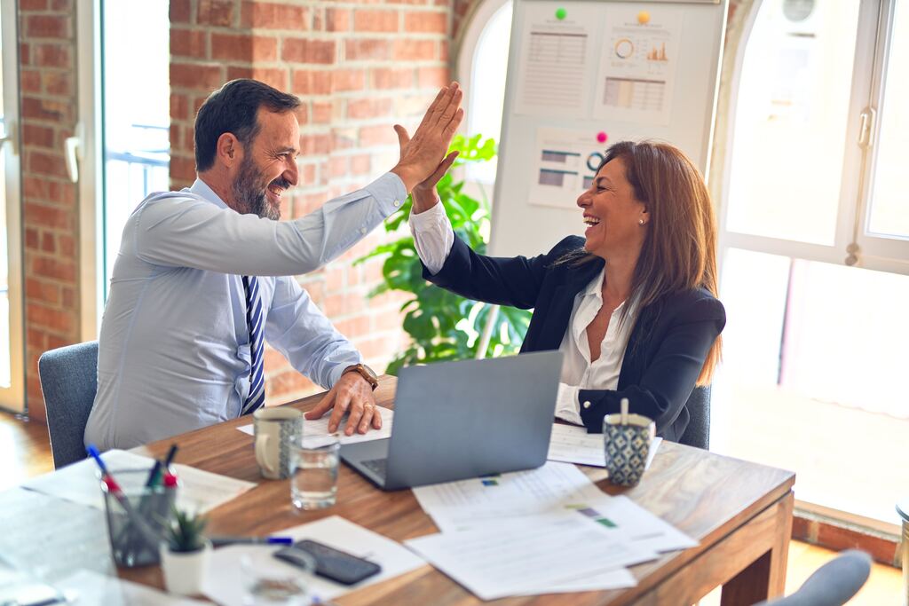 Sales people sitting in an office, symbolizing an efficient sales success story.